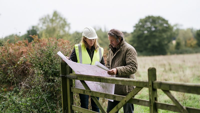 Developers discuss site plans in field